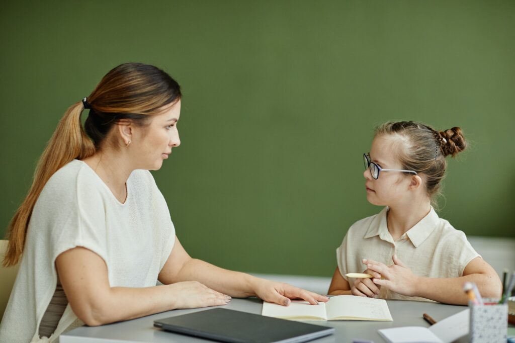Tutor Helping Girl with Down Syndrome Studying